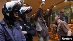 A protester confronts a saleswoman next to policemen during Spain's general strike in Palma de Mallorca on March 29.