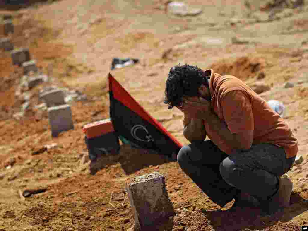 یکی از مخالفان معمر قذافی بر سر مزار کشته‌شدگان ناآرامی‌ها- بریقه، ۲۶ تیرماه ۱۳۹۰