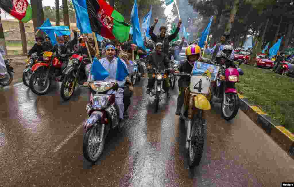 Supporters of Afghan presidential candidate Abdullah Abdullah ride their motorcycles as they lead his convoy after his arrival to attend an election rally in Herat Province. (Reuters/Zohra Bensemra)