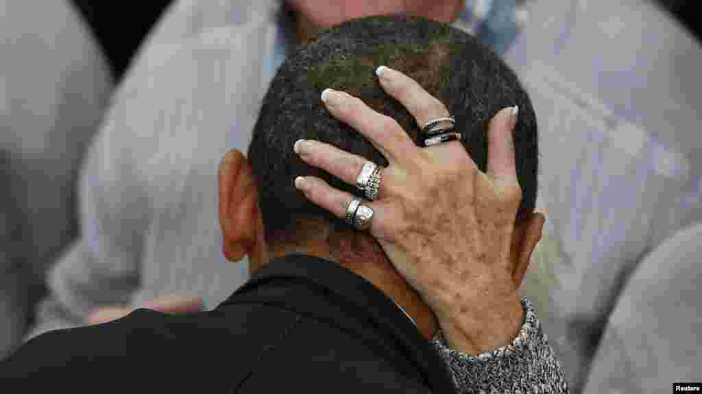 A woman grasps the head of U.S. President Barack Obama as he greets supporters at a campaign event at Springfield High School in Ohio. (Reuters/Larry Downing)