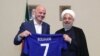 A handout picture released by the office of Iranian President Hassan Rouhani shows him (R) and FIFA President Gianni Infantino holding a football shirt with Rouhani's name during Infantino's visit to the capital Tehran on March 1, 2018.
