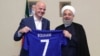 Iranian President Hassan Rohani (right) and FIFA President Gianni Infantino hold up a soccer shirt with Rohani's name during Infantino's visit to Tehran in March 2018.