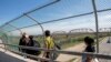  Мигранты из Центральной Америке пересекают пограничный мост, связывающий Мексику с США