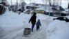 Сын с отцом везут воду на одной из улиц в столице автономного округа Ханты-Мансийске