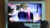 Дональд Трамп и Ким Чен Ын на экране монитора, по котором транслируют передачу южнокорейского телевидения. 