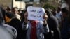 People gathered in front of the governorate of Fars, on January 09, 2017, in protest against satellite jamming emissions in Shiraz. One of the protesters holds a sign that reads "Shiraz, the capital of parasite".