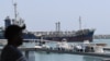 UAE -- A man watches on July 2, 2019 the ships movement in the port of Fujairah in the east of the United Arab Emirates (UAE), where recent tensions spiraling between Iran and the United States have affected movement in the Gulf of Oman, near the strategi