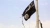 A member of the US-backed Syrian Democratic Forces (SDF), removes an Islamic State group flag in the town of Tabqa on April 30, 2017