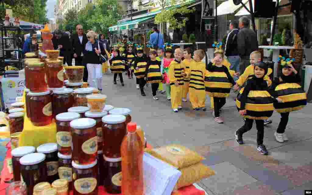 Children in costume march past stands as part of Macedonian Honey Days.