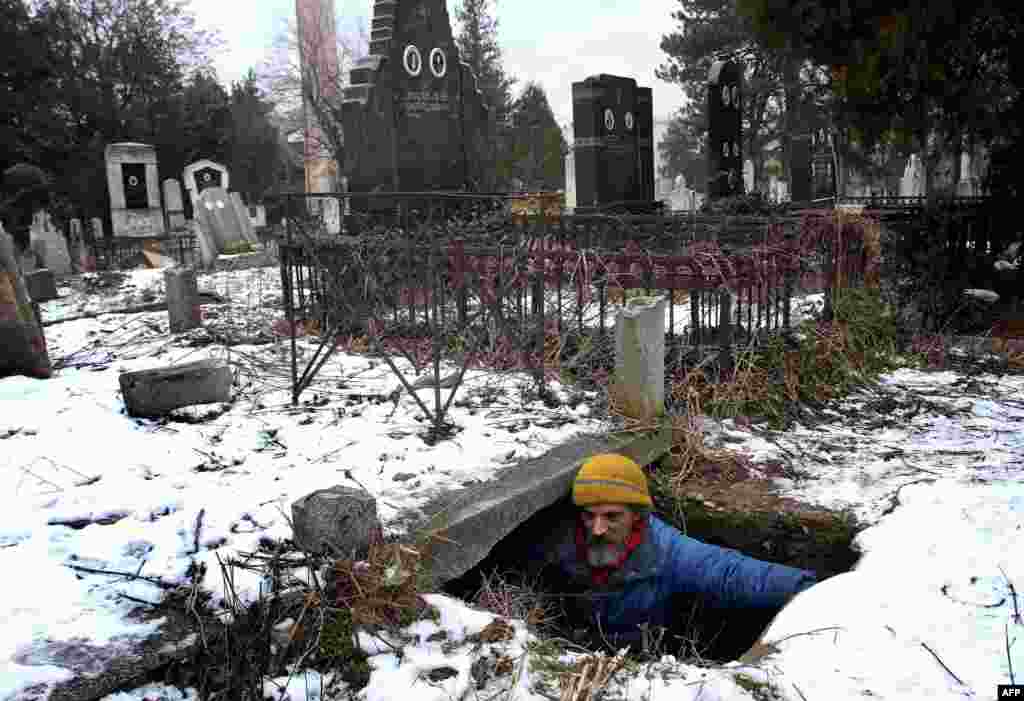 A homeless man, Bratislav Jovanovic, 43, enters a grave that he uses as a shelter during winter at a cemetery in Nis, 200 kilometers south of Belgrade. Jovanovic has been homeless for nearly 20 years, since his house burned down. For the last 15 years he has lived in a tomb beside the caskets of his descendants. (AFP/Sasa Djordjevic)