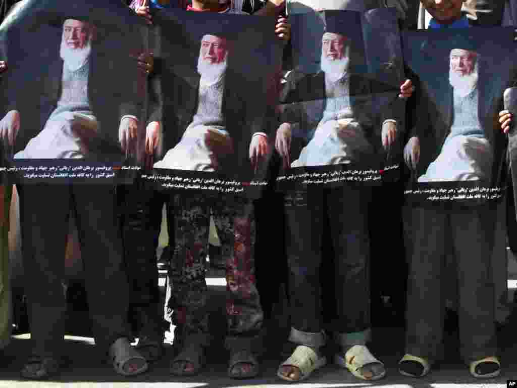 Youths hold portraits of former President Burhanuddin Rabbani during a demonstration in Kabul. (AP photo/Musadeq Sadeq)
