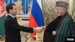 Russian President Dmitry Medvedev (left) greets Afghan President Hamid Karzai in Moscow.