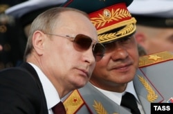 Президент России Владимир Путин (слева) и министр обороны Сергей Шойгу на параде в честь Дня ВМФ России в Мурманской области, 27 июля 2014 года