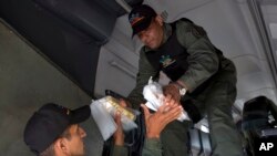 Members of a military agency that transports valuables gold bars from a military plane to be taken to Venezuela's Central Bank, at the Carlota military airport in Caracas, March 1, 2018. 