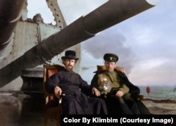Two men (and a cat) aboard the Admiral Kornilov, an armored cruiser of the Russian Navy that was launched in 1902.