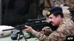 FILE: Raheel Sharif trying a rifle during his visit to the Pakistan Ordnance Factories in April 2015.