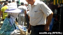 Ўзбекистон. Жазирама иссиқдан юзини ниқоб билан тўсган аёл сигарета сотмоқда. (Озодлик архивидан)