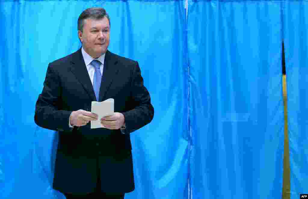 Ukrainian President Viktor Yanukovych holds his ballot at a polling station in Kyiv.