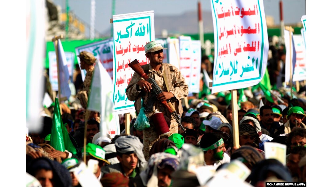 شبهنظامی حوثی روز سهشنبه در صنعا در کنار پرچم حوثیها، با شعارها مرگ بر آمریکا و اسرائیل و شعار لعنت به یهودیان. حوثیها از حمایت جمهوری اسلامی برخوردار هستند.