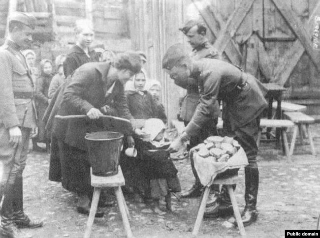 Сотрудники ARA раздают пищу голодающим детям