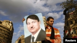 A protester holds a placard depicting Egyptian President Hosni Mubarak as Adolf Hitler in Cairo's Tahrir Square on January 31.