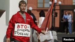 A lone anti-WTO protester distributes leaflets outside the State Duma in Moscow on July 10.