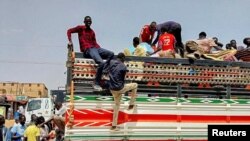 La periferia capitalei Sudanului, oamenii părăsesc zona în camioane. Imagine din 28 aprilie 2023