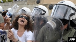 A woman protests in front of the Greek parliament during a demonstration march against austerity measures earlier this year.