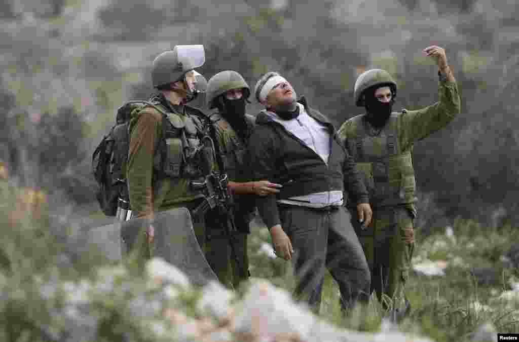 Israeli soldiers detain a Palestinian protester during clashes following a protest against the nearby Jewish settlement of Qadomem, in the West Bank village of Kofr Qadom near Nablus, on January 2. (Reuters/Abed Omar Qusini)