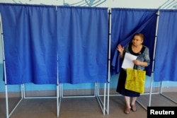 A woman exits a voting booth at a polling station in Donetsk on September 8.