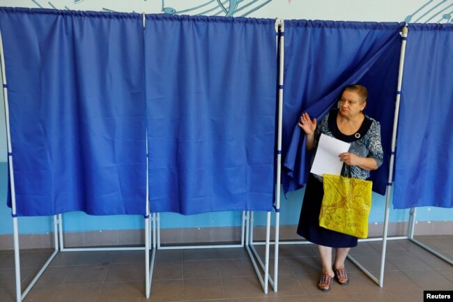 A woman exits a voting booth at a polling station in Donetsk on September 8.