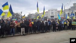 Helyi lakosok ukrán zászlóval tüntetnek az orosz megszállás elleni demonstráción az ukrajnai Herszonban, a Szabadság téren 2022. március 5-én