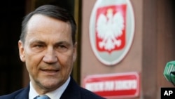 Ministrul de externe al Poloniei, Radek Sikorski, vorbește cu presa în fața Ministerului de Externe din Varșovia, Polonia, 22 octombrie 2024.