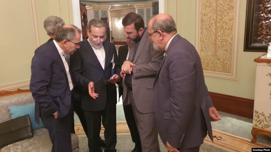Iran's foreign minister, Abbas Araqchi (second left), and other members of the Iranian delegation confer at the talks in Muscat on April 12. 