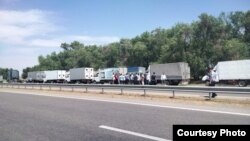 Водители и грузовые автомобили на обочине трассы в Туркестанской области. 31 мая 2021 года.