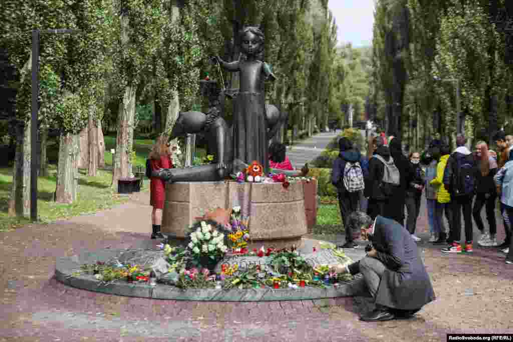 На фото: человек возлагает цветы к памятнику детям, расстрелянным нацистами в Бабьем Яру