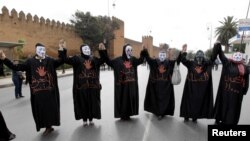 Halkara 8-nji mart baýramçylygynda maska geýip, protest şygarlaryna gygyrýan morokkaly aýallar. Arhiw suraty