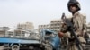 An Iraqi soldier stands guard near a damaged truck at the site of a road side bomb last week