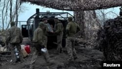 Артилеристи 147-ї десантно-штурмової бригади розвантажують  патрони для гаубиці поблизу прифронтового міста Покровськ у Донецькій області, березень 2026 року