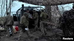 Артилеристи 147-ї десантно-штурмової бригади розвантажують патрони для гаубиці поблизу прифронтового міста Покровськ у Донецькій області, 30 березня 2026 року