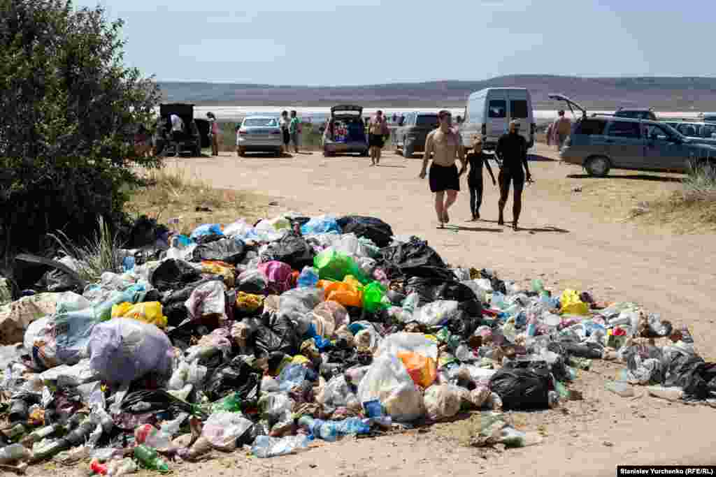 Avgust 2015 senesi. Aşağı Otuz (Kurortnoye) köyüniñ yanındaki Çoqraq gölüniñ yalısı. Turistler raatlanğan plâjı yanında çöplük obaları.