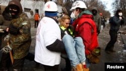 Валянтэры выносяць параненую журналістку зь месца сутычак на вуліцы Грушэўскага, 20 студзеня.