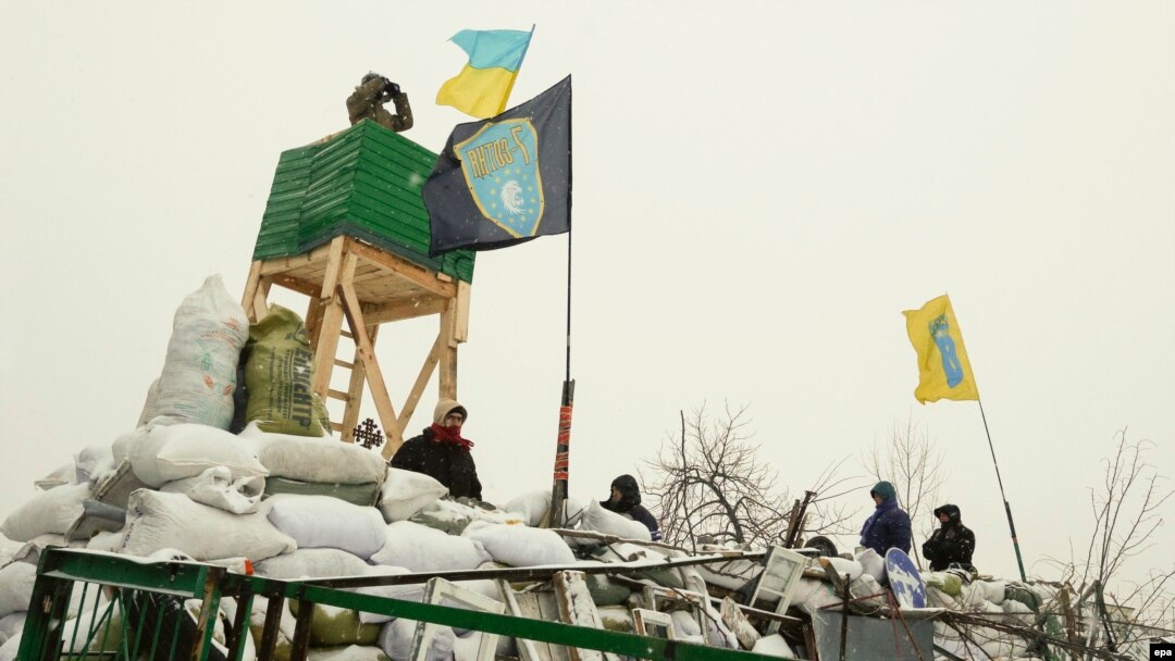 Ukrainian protesters stand guard on a barricade with a recently built watchtower during their continuing protest in Kyiv on January 29.