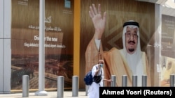 Pešak prolazi pored plakata sa fotografijom kralja Salmana u Džedi, Saudijska Arabija, jul 2021.