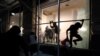 A man jumps from the window of a damaged store as protests against the death in Minneapolis police custody of George Floyd continue, in New York City, U.S., June 2, 2020. REUTERS/Jeenah Moon 