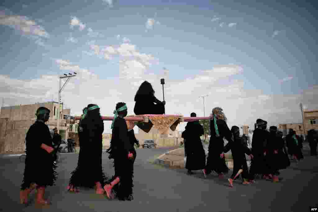 Performers portraying genies carry Zaafar Jinni, the king of genies.