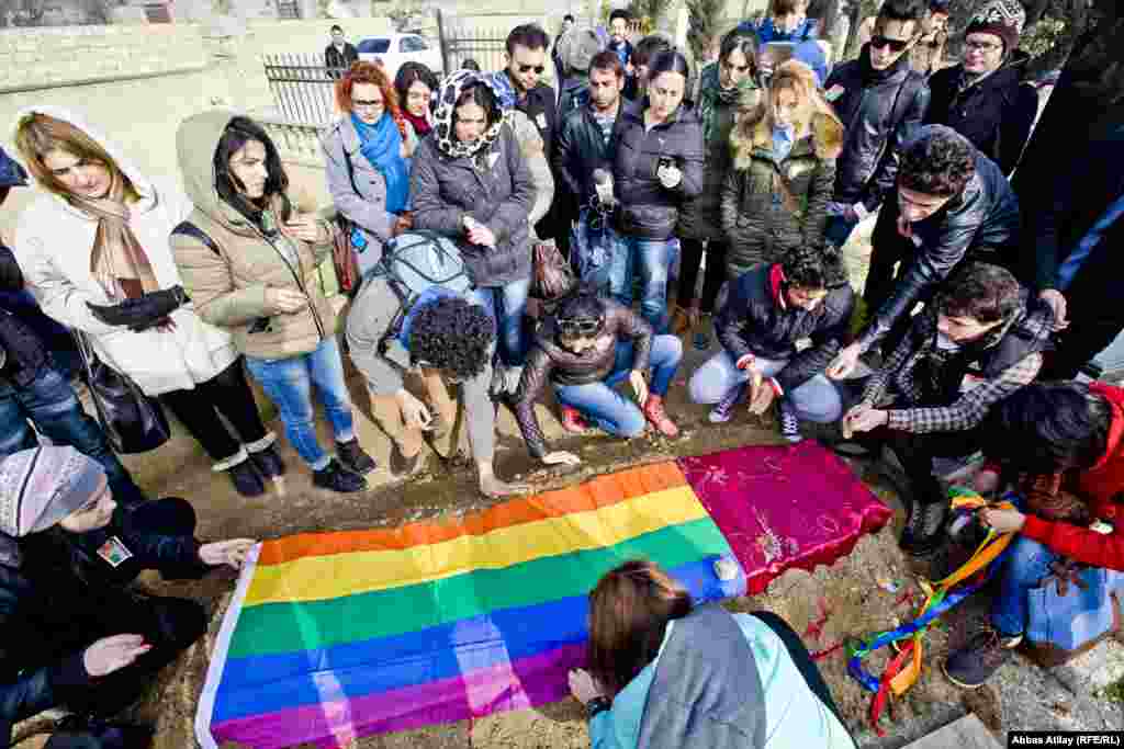 Dostları LGBT bayrağını məzar üzərinə sərir.