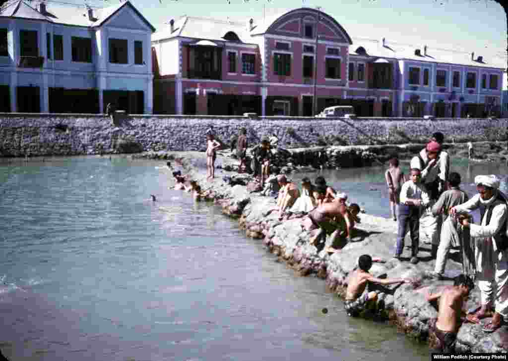 Men and boys washing and swimming in the Kabul River.