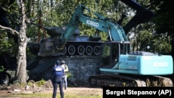 Muncitorii înlătură un tanc sovietic T-34 din cadrul unui monument din Narva, Estonia, 16 august 2022