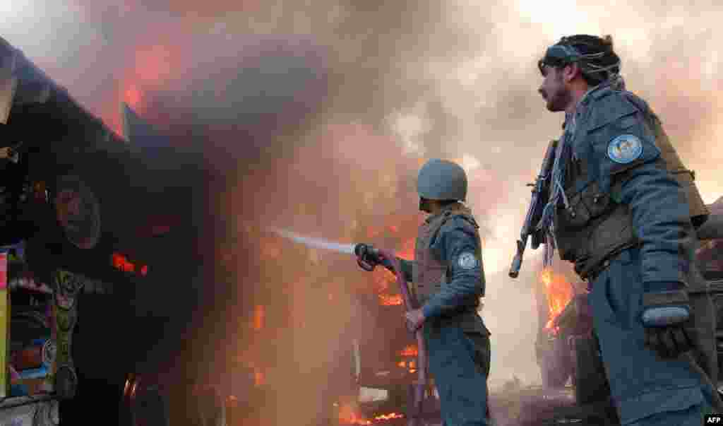 Afghan firefighters extinguish burning NATO military vehicles after a clash between Taliban and Afghan security forces in the Torkham area, near the Pakistan and Afghan border in Jalalabad, on December 18. (AFP/Omar Gul)